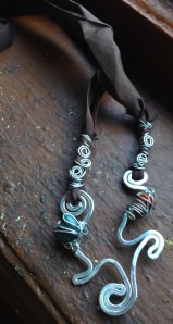 Rich chocolate brown ribbon paired with waves of silver wrapped with goddess spirals, deep green and carnelian